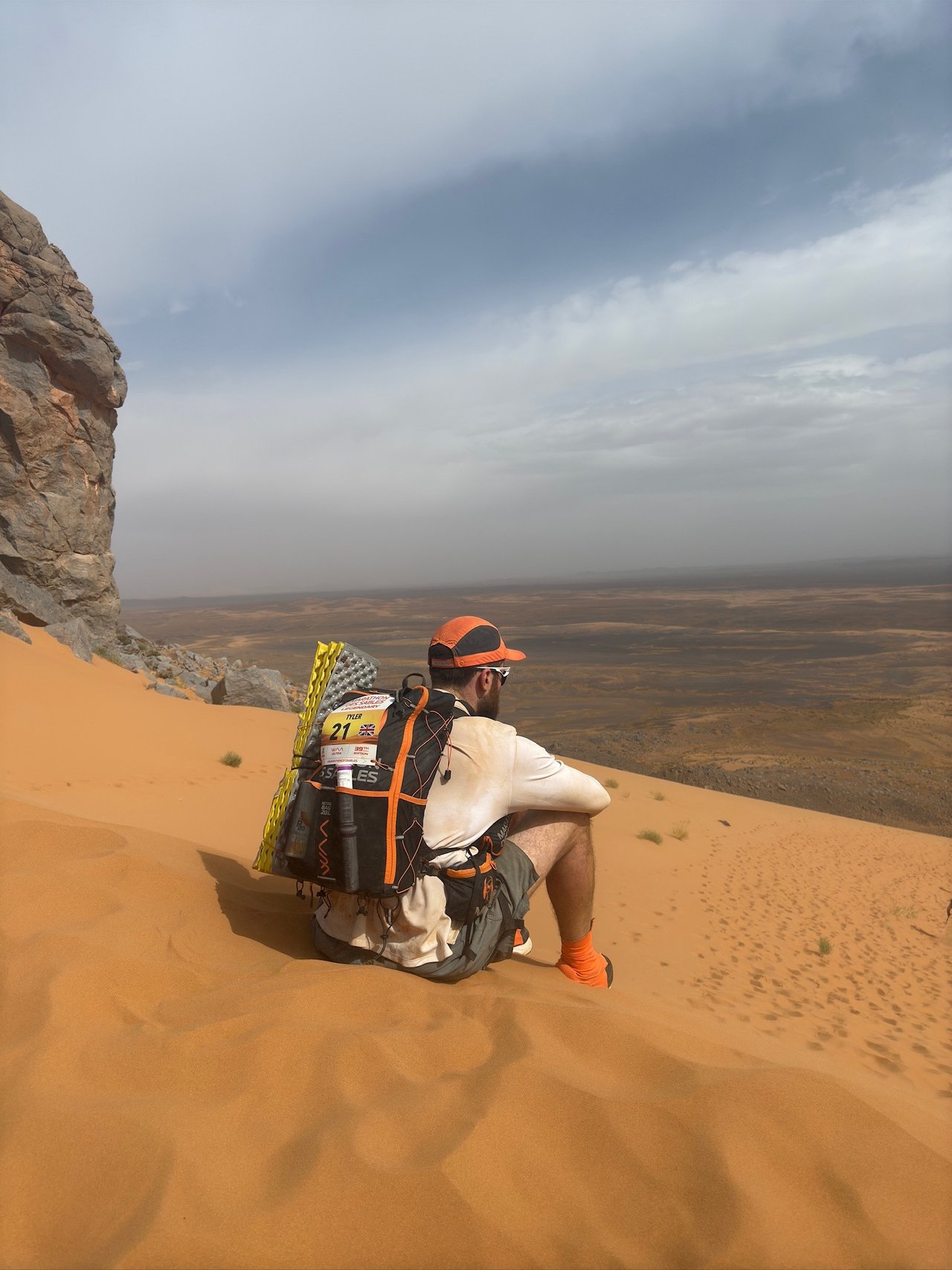 Tyler sat on sand dune mid run